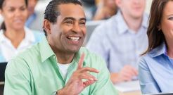 Male student in class raising hand