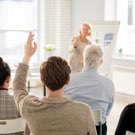 student raising hands in a classroom