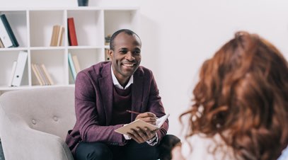 Male therapist speaking with female patient-alt-text