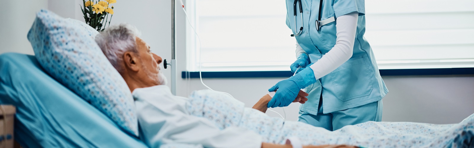 Nurse practitioner drawing a line on a male patient lying in a hospital bed