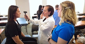 physician assistant teaching two female students in a classroom