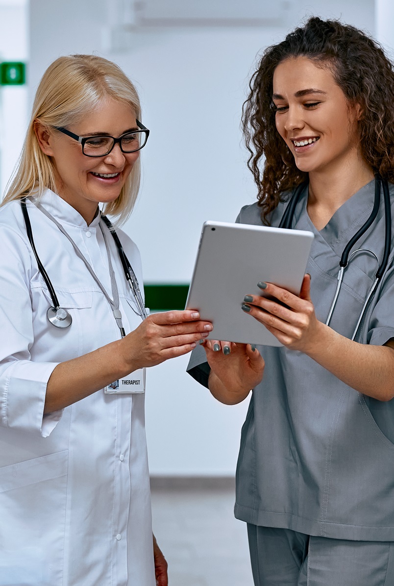 two women healthcare workers discussing findings on a tablet