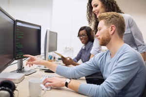 small group of professionals discussing code on a computer screen