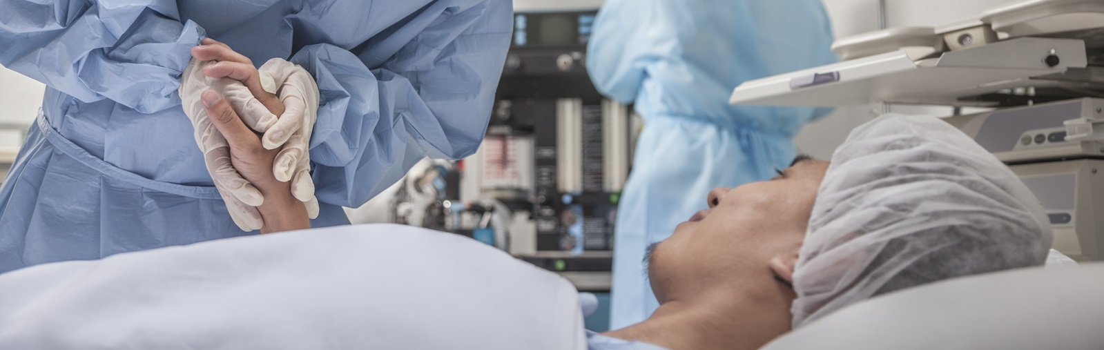 woman healthcare worker holding a patient's hand in the hospital room