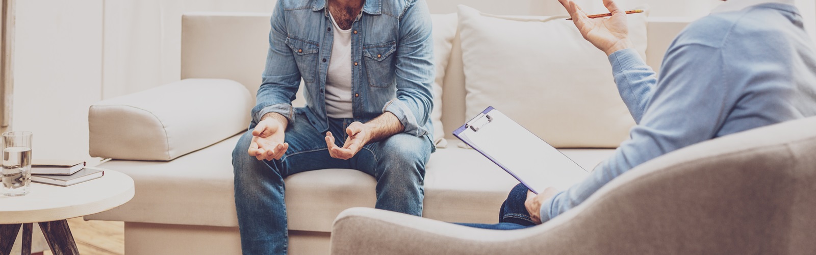 Male psychologist speaking with a patient in an office setting