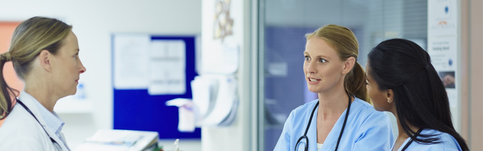 three women healthcare workers speaking in a hospital