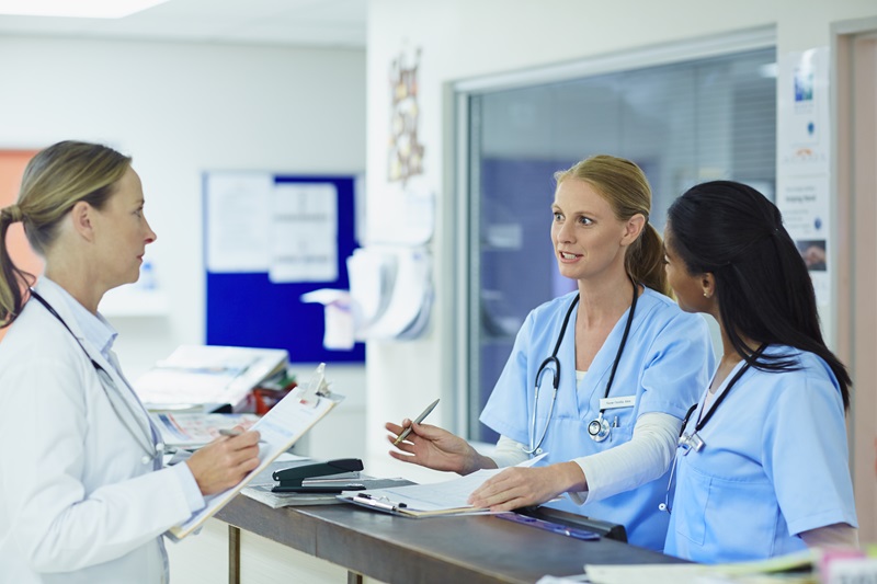 three women healthcare workers speaking in a hospital