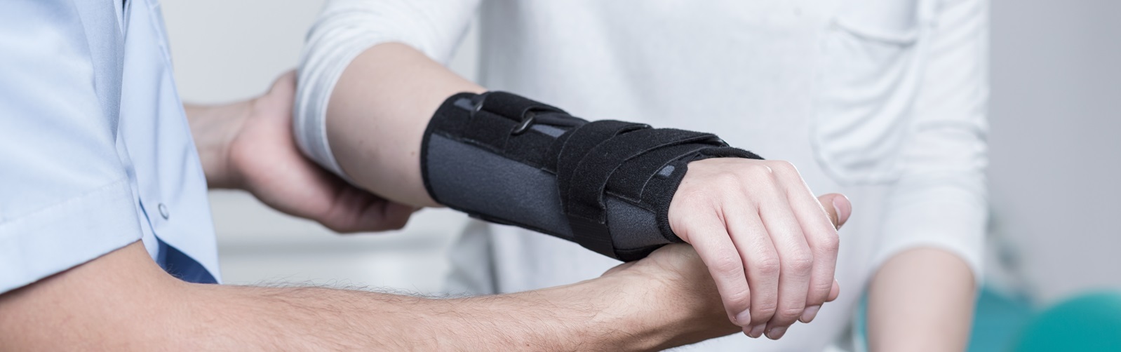 Physical Therapy Assistant assisting a patient with an arm in a cast