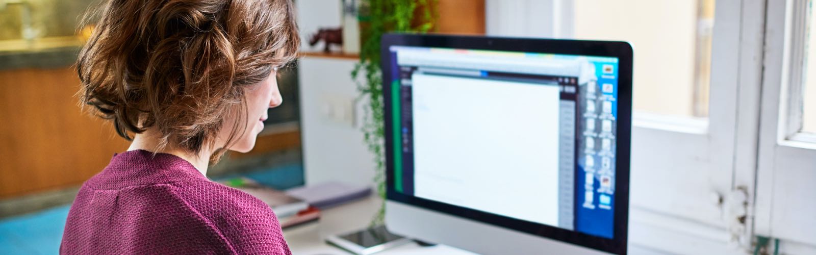 Young woman working on computer in home office