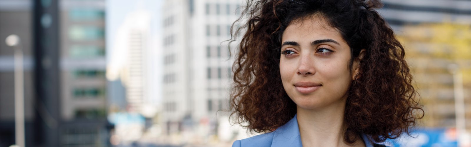 Young woman in business atire walking in city