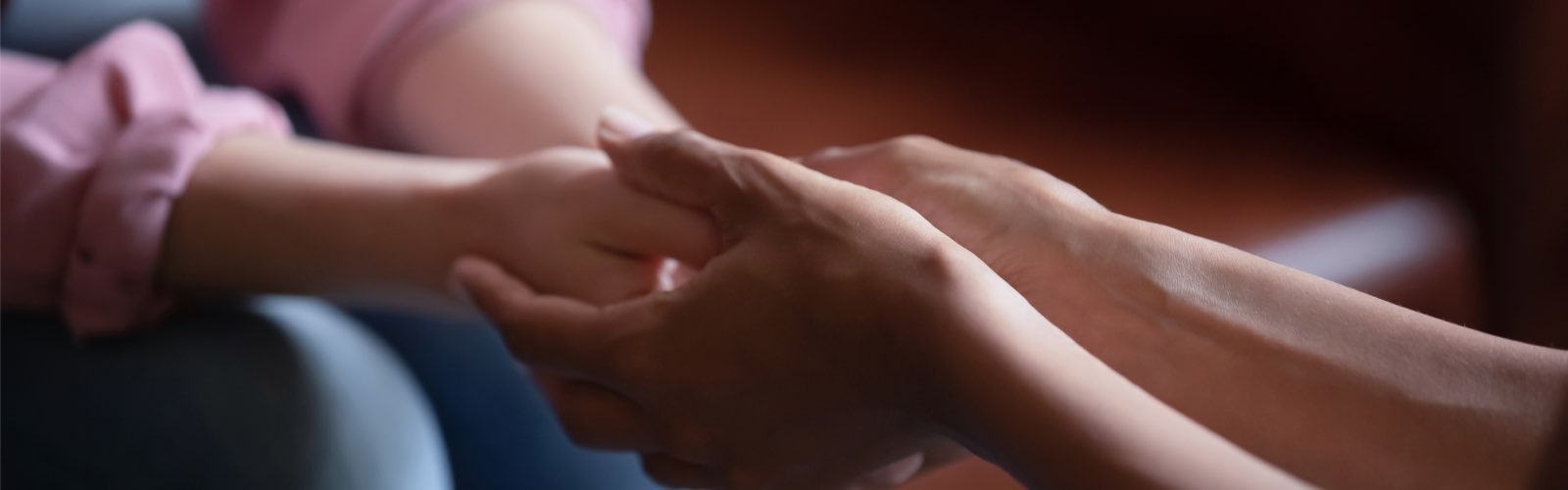 Counselor holding hands of patient