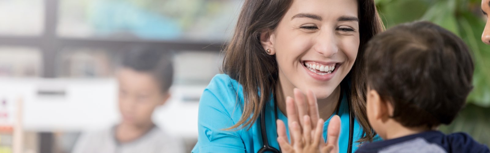 Female nurse smiling with child patient