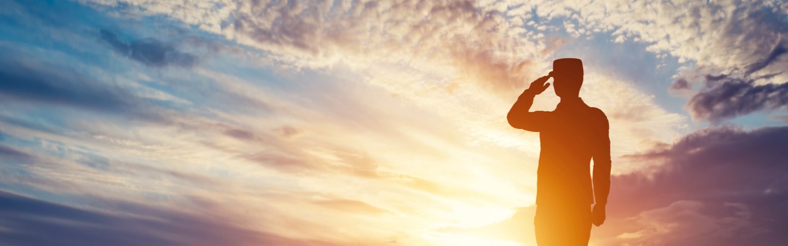 Soldier saluting at sunset