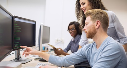 small group of professionals discussing code on a computer screen